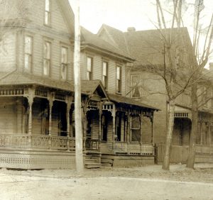 Three old wood frame houses in a row.