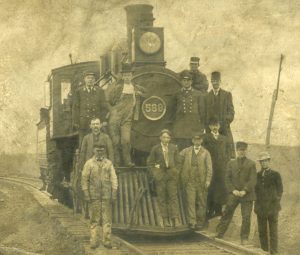 A train locomotive with its crew, posing for a portrait.